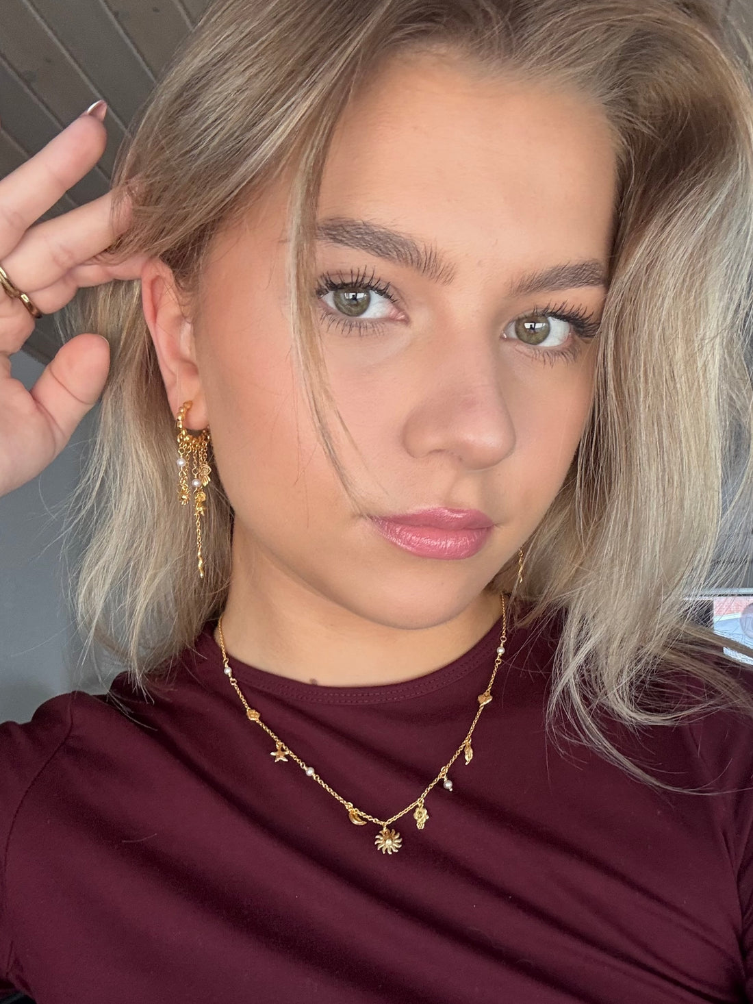 Guldbelagte creoler med stjerne, sol, måne, hånd, slangevedhæng og ferskvandsperler – fremstillet i forgyldt sølv for et himmelsk look. Inspireret af Pallantis Smykkers Ocean Secret Øreringe.